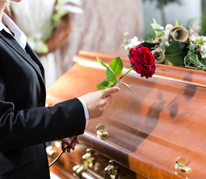 Placing a rose on a casket, we can arrange your family's traditional burial